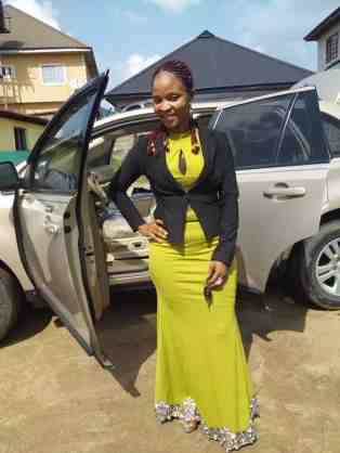 Esther Ogubio posing with her brand new car